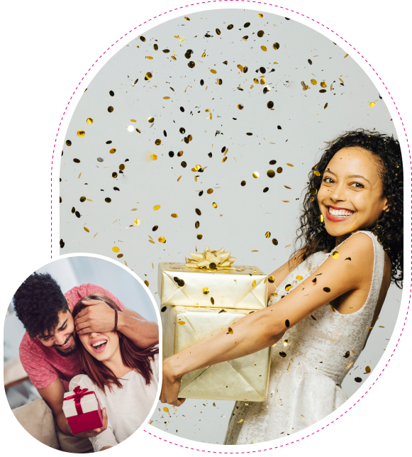 A joyful woman holding a gift box with confetti falling around her.
